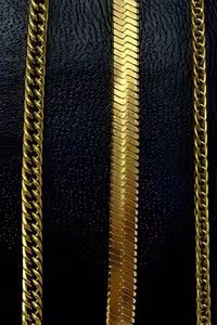 three gold chains displayed on a black textured background