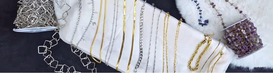 A collection of necklaces and bracelets laid over a white plate surrounded by gemstone chains