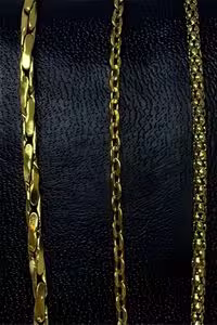 three gold chains displayed on a black textured background